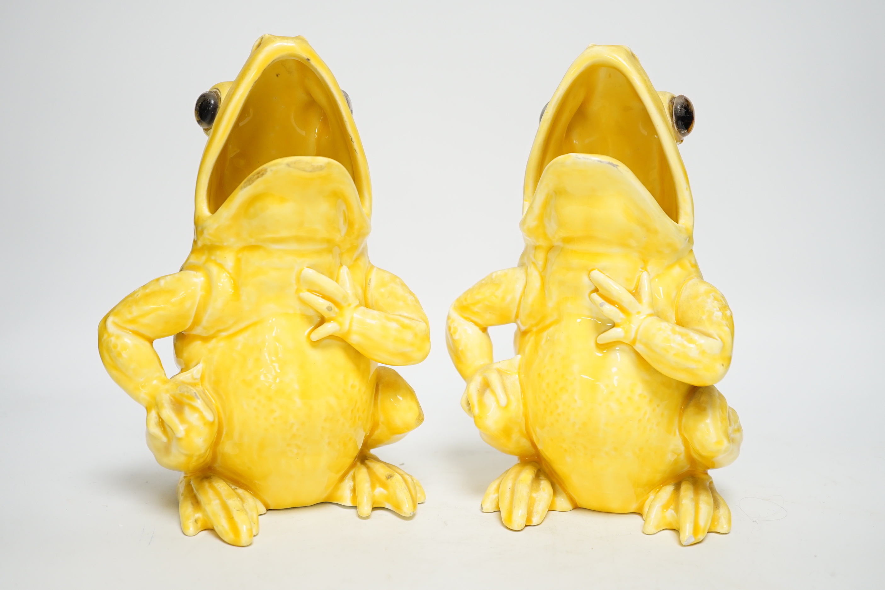 A pair of Continental yellow glazed pottery frogs, 21.5cm